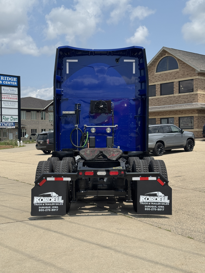 Rear view of a blue Peterbilt 579 tractor with sleeper cab, displaying dual rear wheels and KTM bumper area.