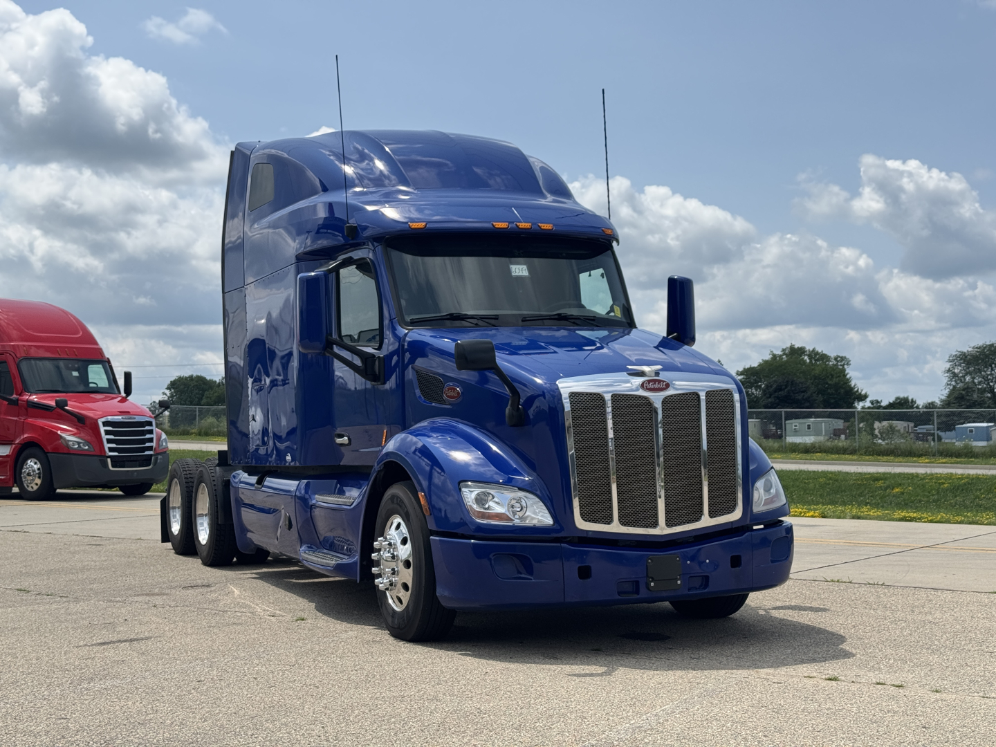 Peterbilt 579 tractor unit in blue, front three-quarter view, with chrome grille, dual headlights, and sleeper cab.