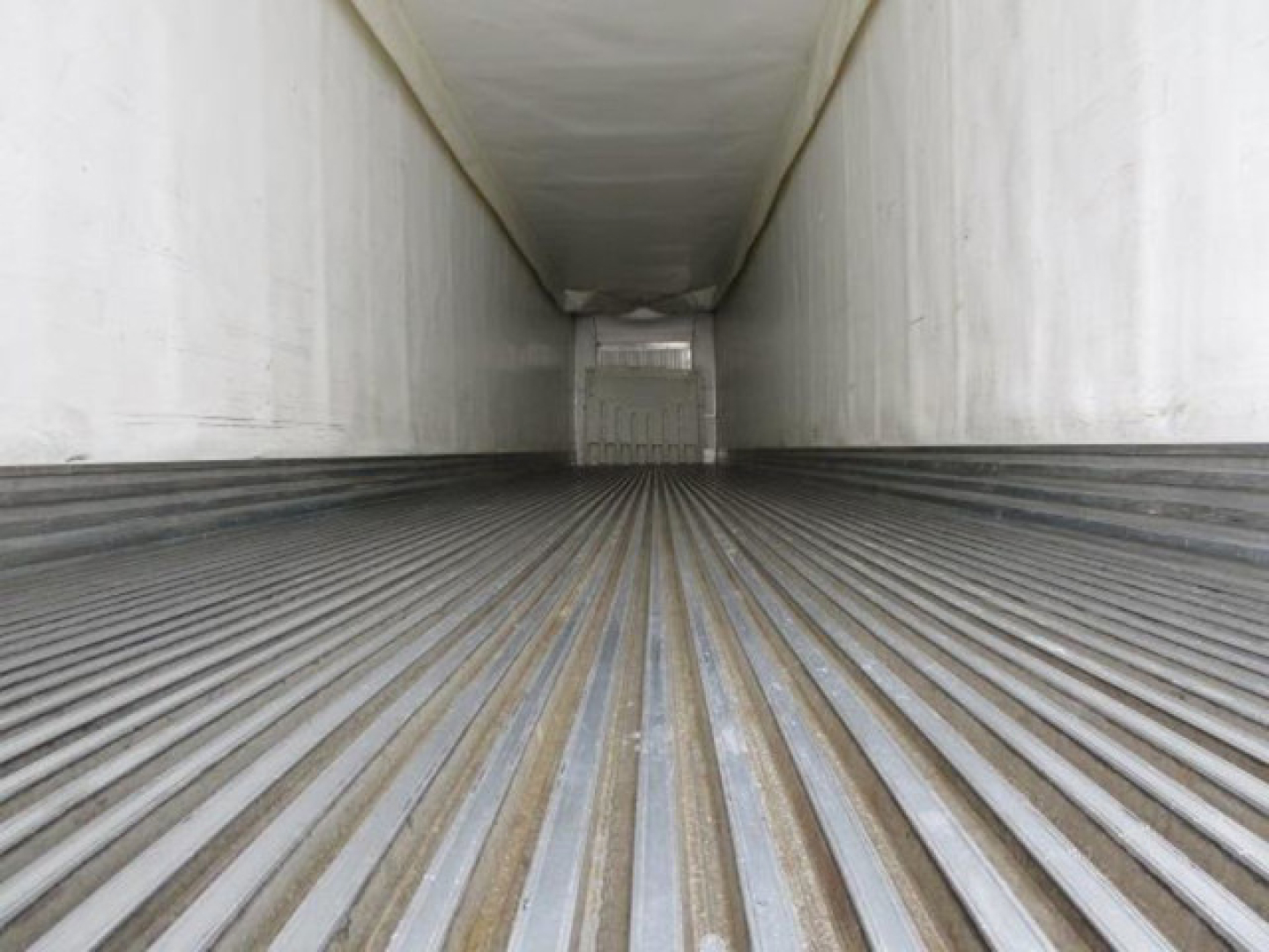Inside view of a refrigerated 2019 Utility trailer cargo space with ribbed floor and white interior walls.