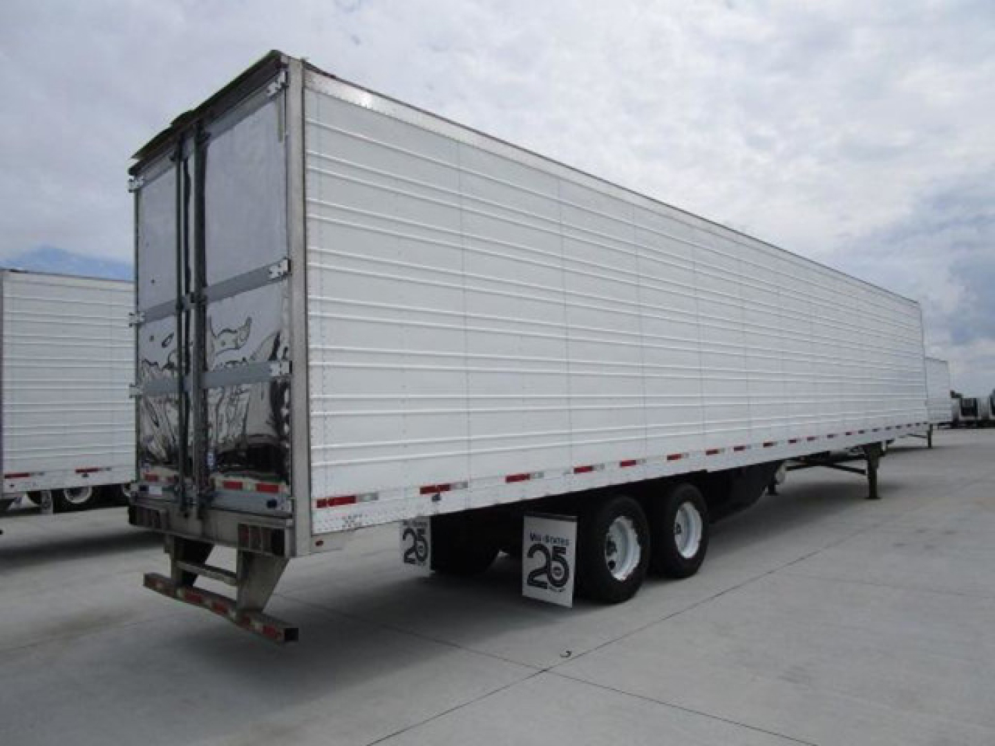Trailer side view of a 2019 utility reefer trailer showing steel corrugated side panels and tandem axles.