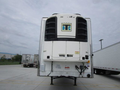 Refrigerated trailer front view showing cooling unit and hitch area with hoses and wires.
