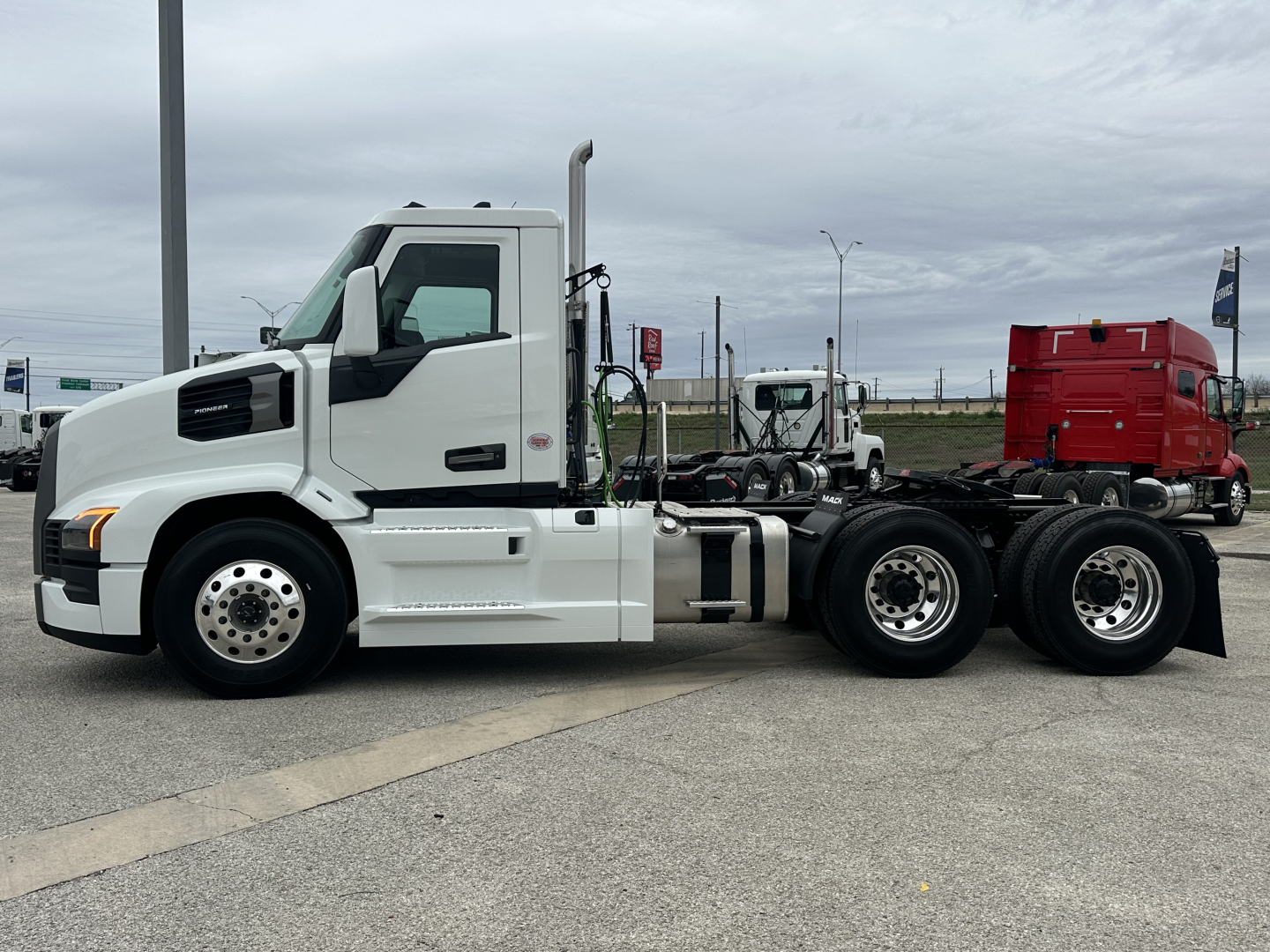 White 2026 Mack PR64T conventional daycab with dual rear axles, side view showing cab, chassis, and fifth wheel mount. 