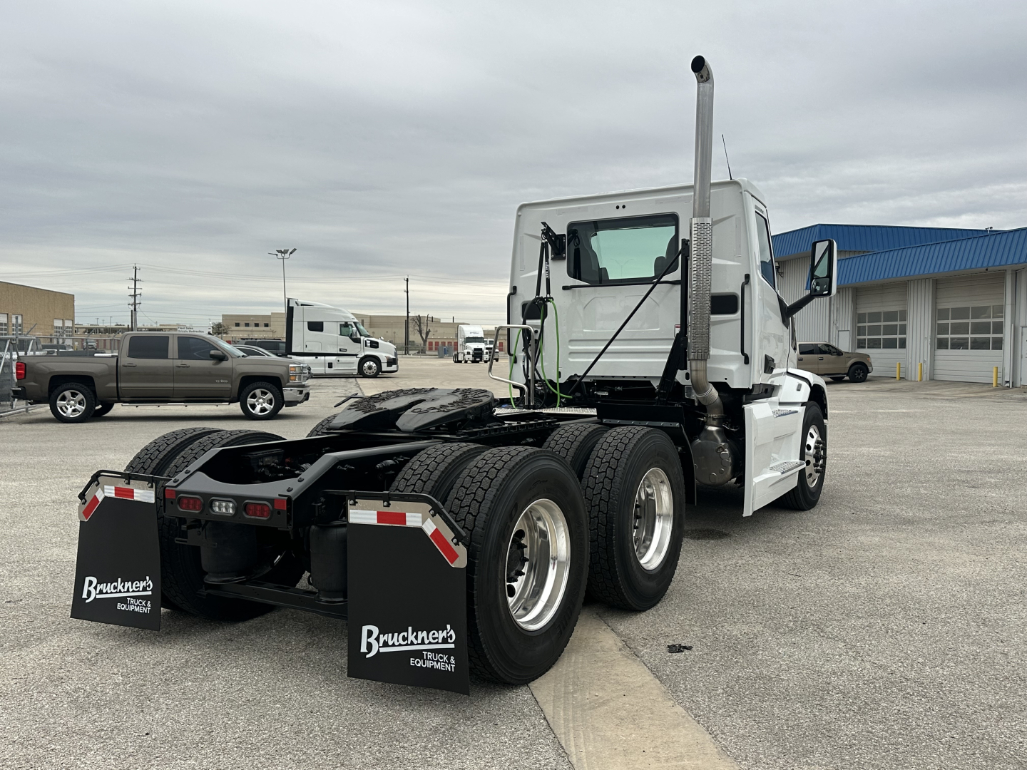 Truck chassis and cab of a 2026 Mack PR64T daytime view showing rear dual axles and exhaust stack.