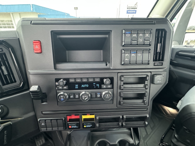 Mack PR64T dash showing ignition switches, climate controls, and storage compartments with control panels and labeled switches.