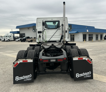 Rear view of 2026 Mack PR64T truck tractor showing dual rear axles, fifth wheel, mudflaps with Bruckner’s Truck & Equipment logo, exhaust stack, and rear lights.