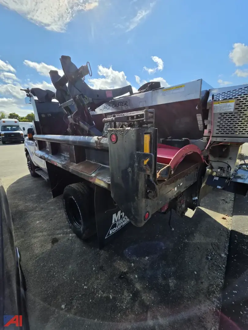 Ford F-350 Super Duty dump truck rear view with dual rear wheels and metal bed, tailgate hoist, and hydraulic components visible.