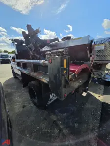 Ford F-350 Super Duty dump truck rear view with dual rear wheels and metal bed, tailgate hoist, and hydraulic components visible.