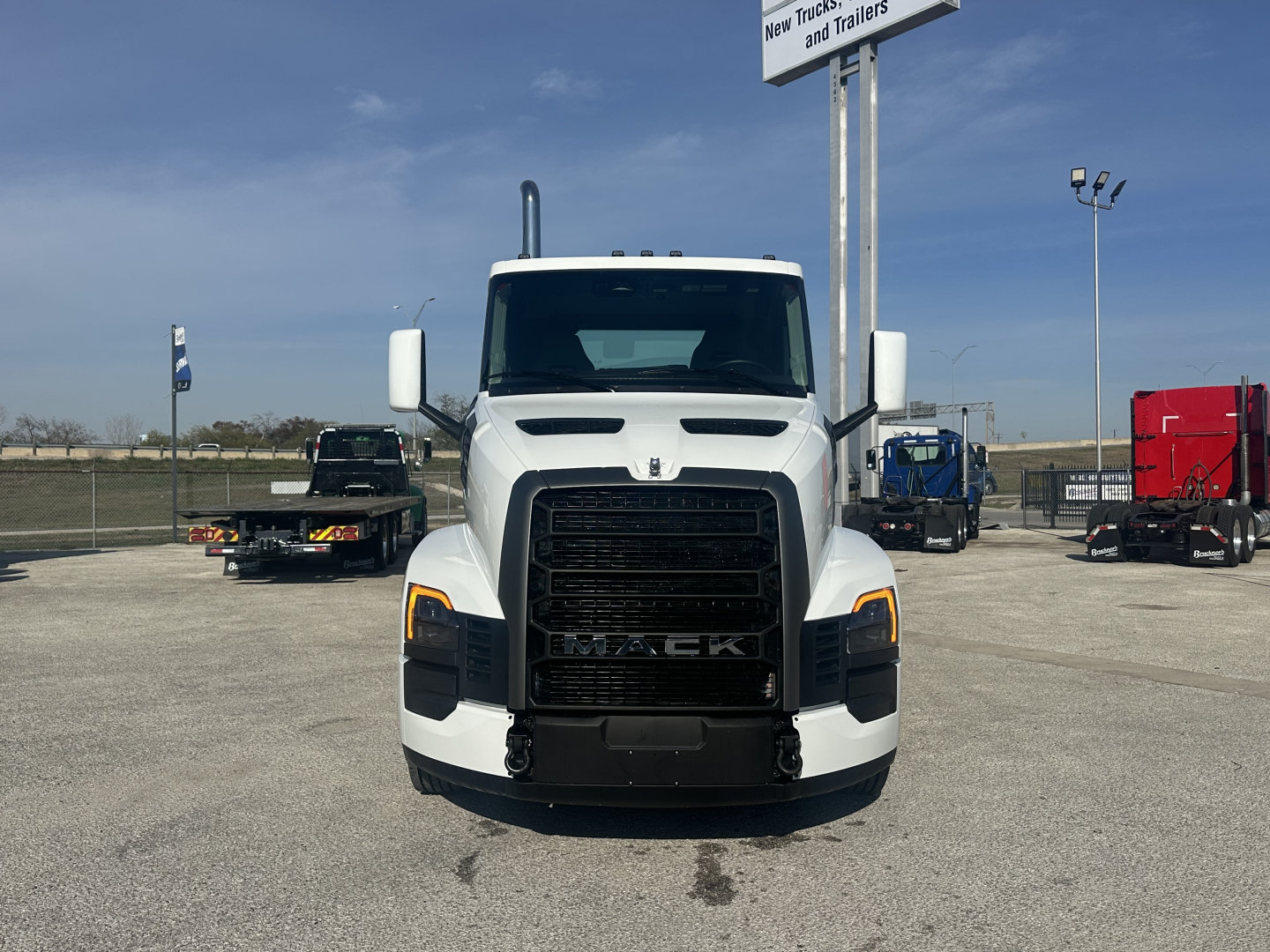 Front view of 2026 Mack PR64T truck in showroom lot showing grille with MACK badge and headlights.
