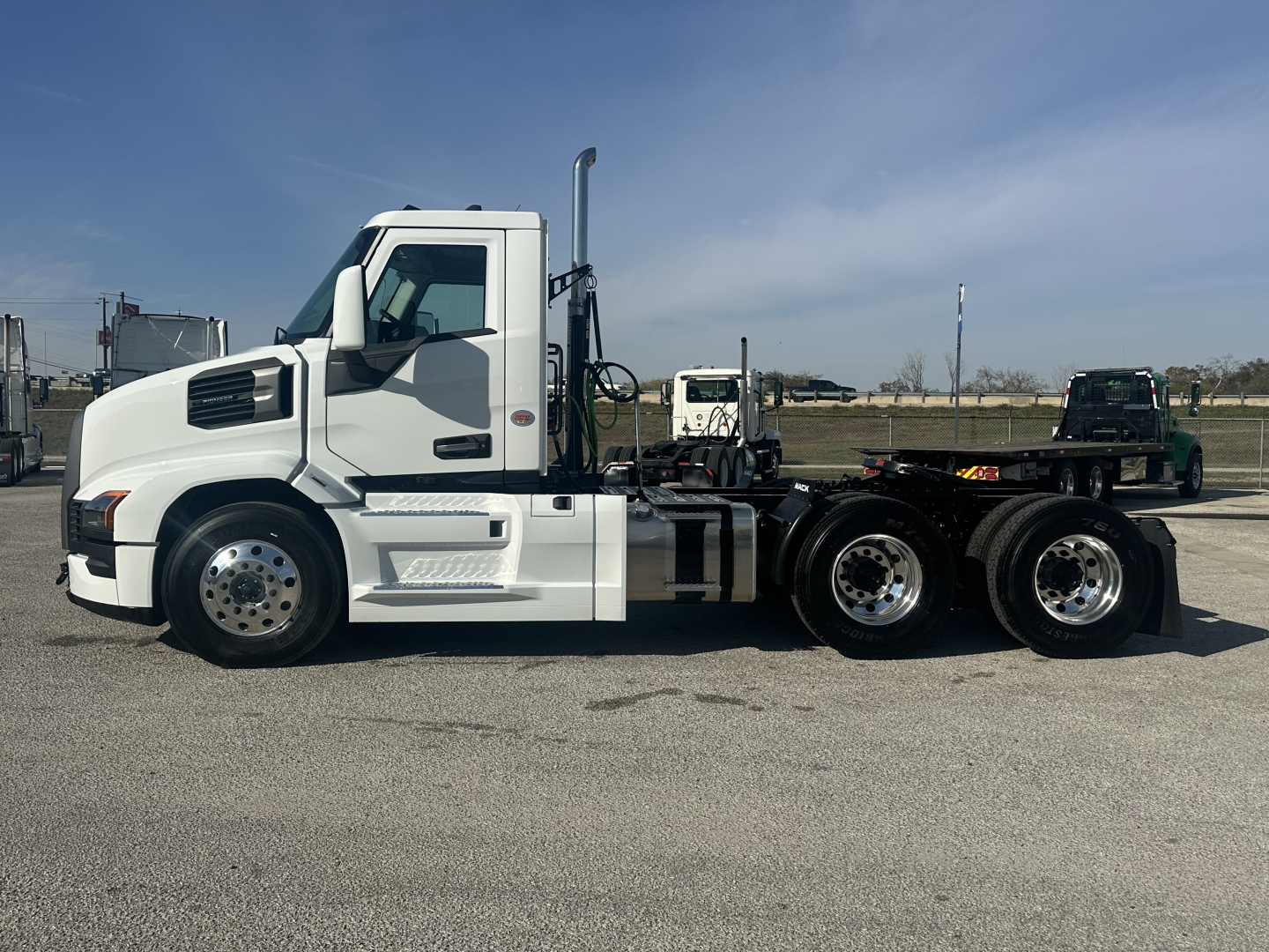 Mack PR64T conventional daycab tractor in white, side profile showing sleeper cab, dual rear axles, chassis, and steps.