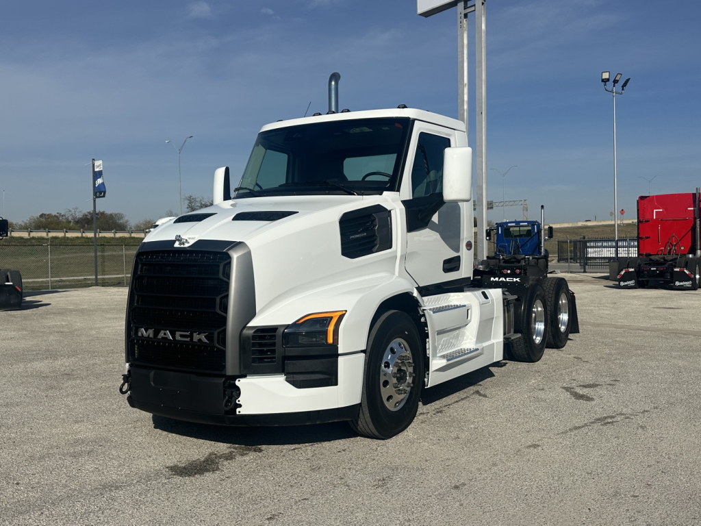 White 2026 Mack PR64T conventional daycab truck in a parking lot, front-left view with dual rear axles and black grille
