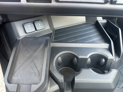 Dashboard and center console of a new 2026 Mack PR64T showing cup holders and auxiliary switches.