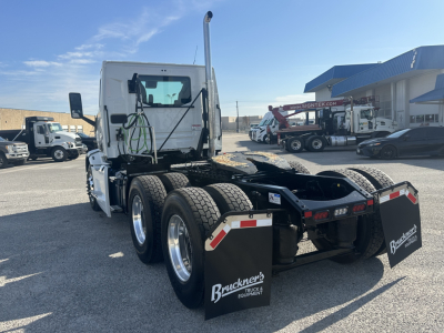 Rear view of a white 2026 Mack PR64T tractor with dual rear axles and large black mud flaps. Visible are 'Buckner's' branding on mud flaps and reflective chevrons on the rear.