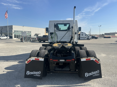 Truck rear view showing fifth wheel, dual rear axles, mudflaps with Buckner's Truck & Equipment logo, and safety reflectors on the fenders.
