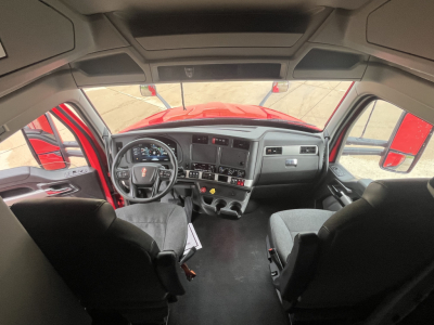 Kenworth T680 truck interior cab view from behind front seats showing dashboard, steering wheel, and center console.
