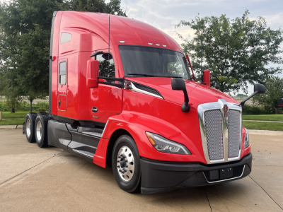 Kenworth T680 sleeper tractor in red, front-left view showing large grille, aerodynamic hood, side mirrors, and dual rear axles.