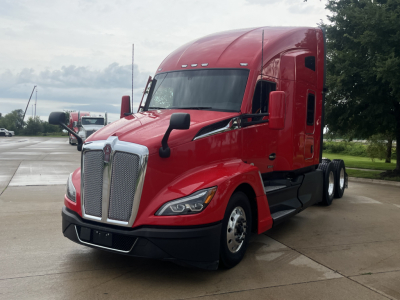 Kenworth T680 tractor unit in red, front-left view showing grille, headlights, and aerodynamic mirrors.