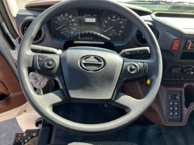 Steering wheel view inside 2025 Hino L7 cab showing dashboard gauges and steering controls.