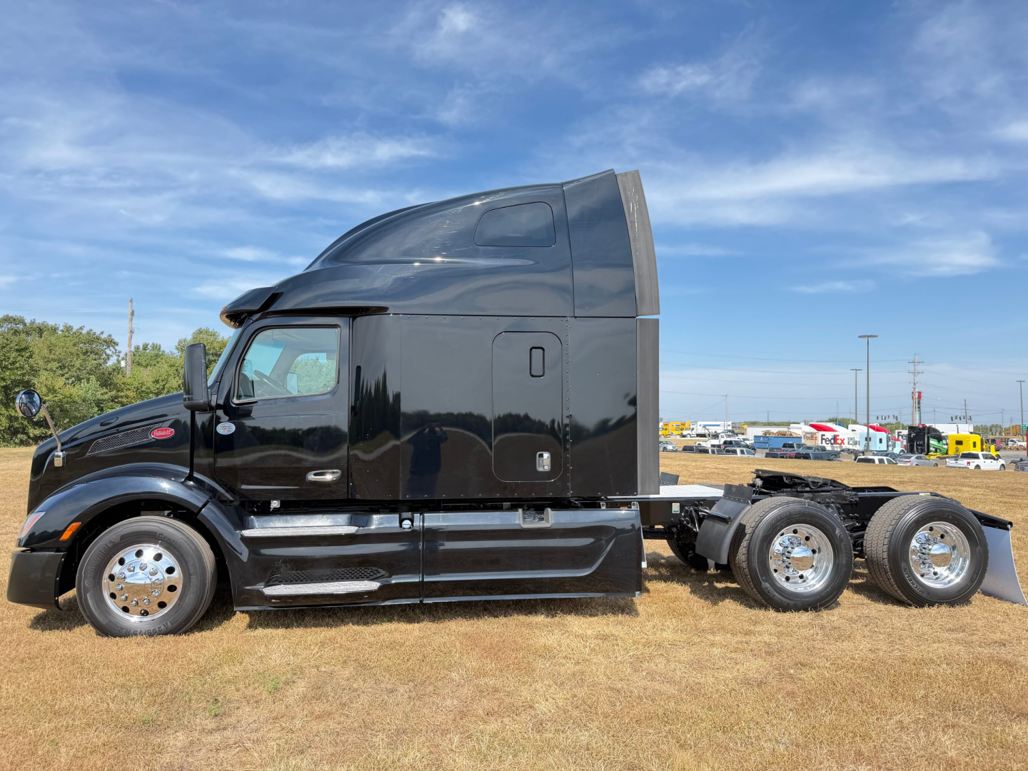 Peterbilt 579 tractor cab side view in black, sleeper with chrome accents, six-wheel rear, no trailer attached.