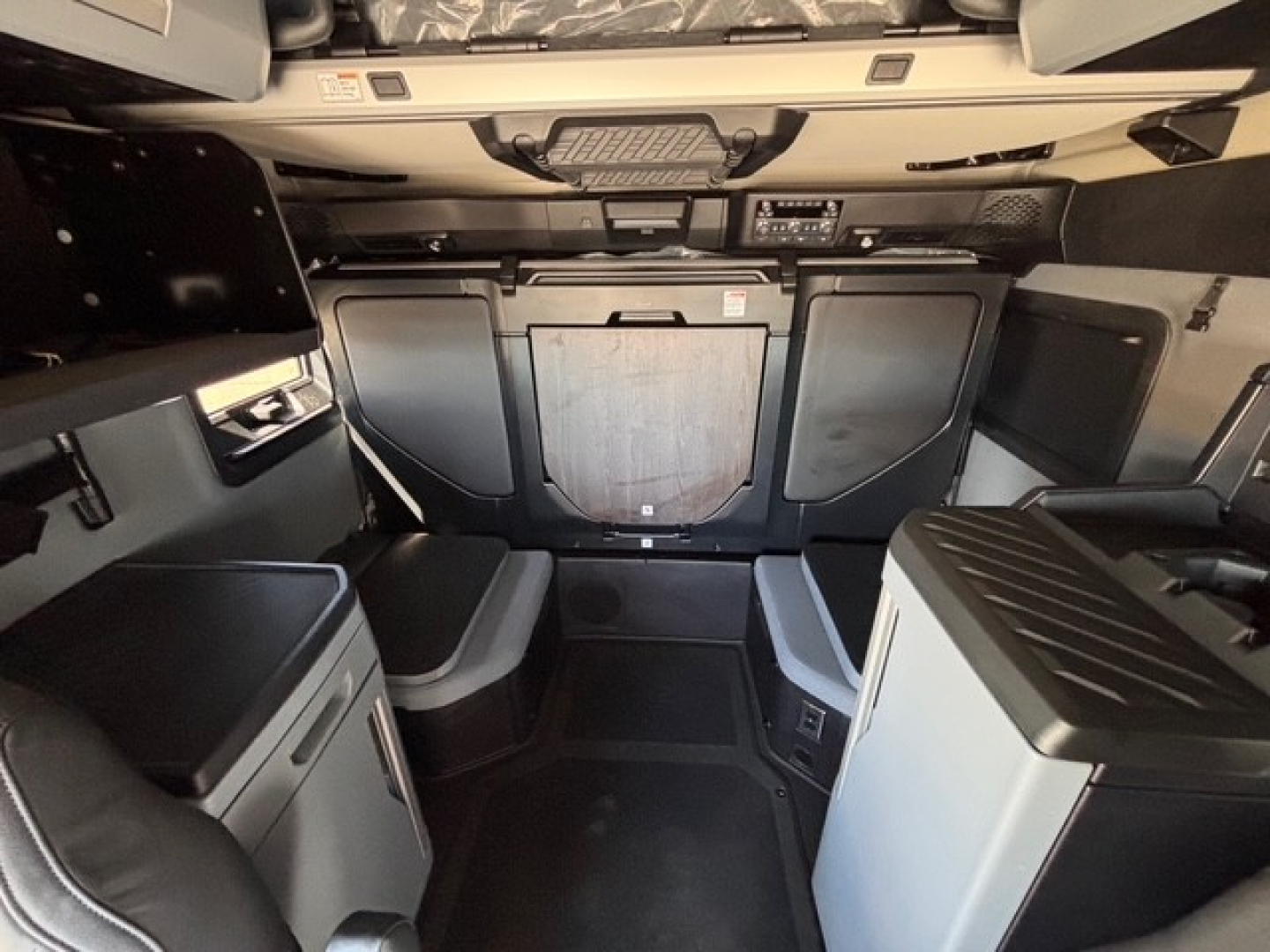 Mack PR64T76H truck cab interior showing sleeper area and dashboard console.