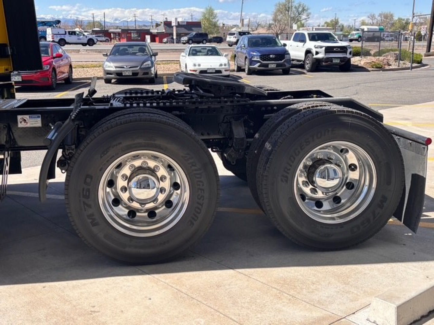 Mack PR64T76H tractor trailer chassis with dual rear axles showing Bridgestone tires and polished wheels.