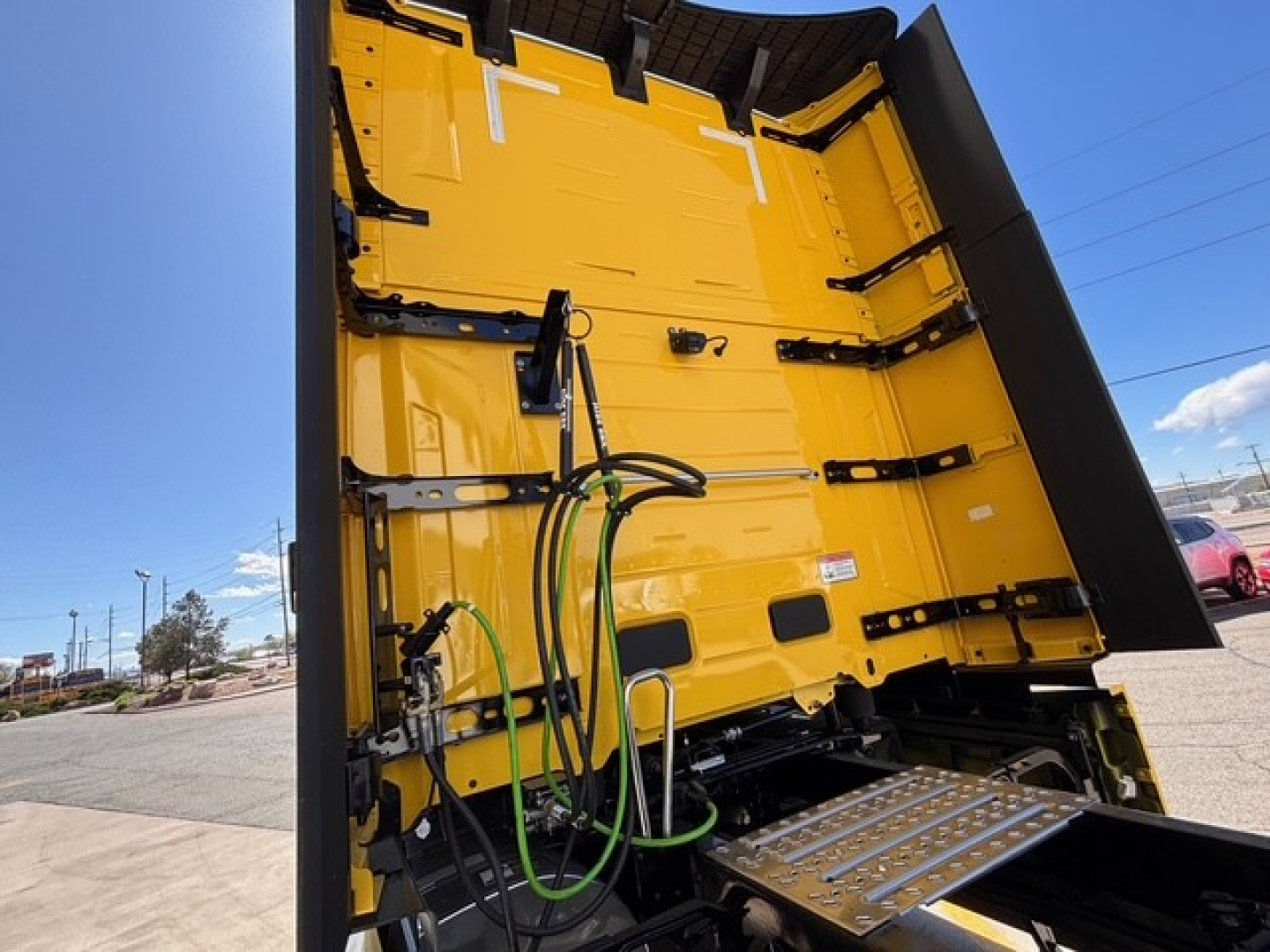 Mack PR64T76H dump bed showing hydraulic lines and metallic steps inside dumping area.