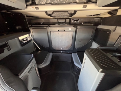 Mack PR64T76H truck cab interior showing sleeper area and dashboard console.