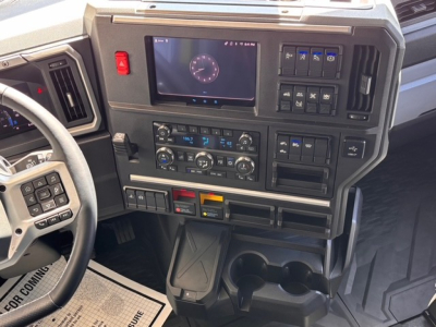 Mack PR64T76H truck interior dashboard showing touchscreen display and climate controls with cup holders.