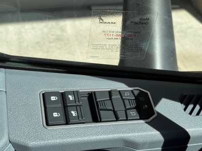 Truck interior: window sticker visible on windshield, power window and mirror control panel on door with multiple switches.