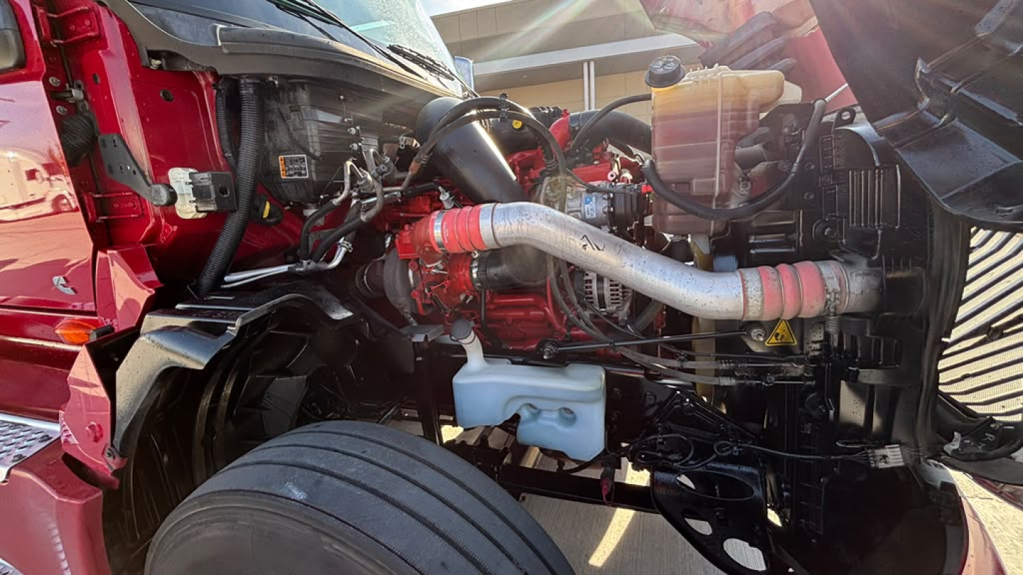 Engine bay of a 2022 International LT625 truck showing radiator hoses, coolant reservoir, and engine components in view.