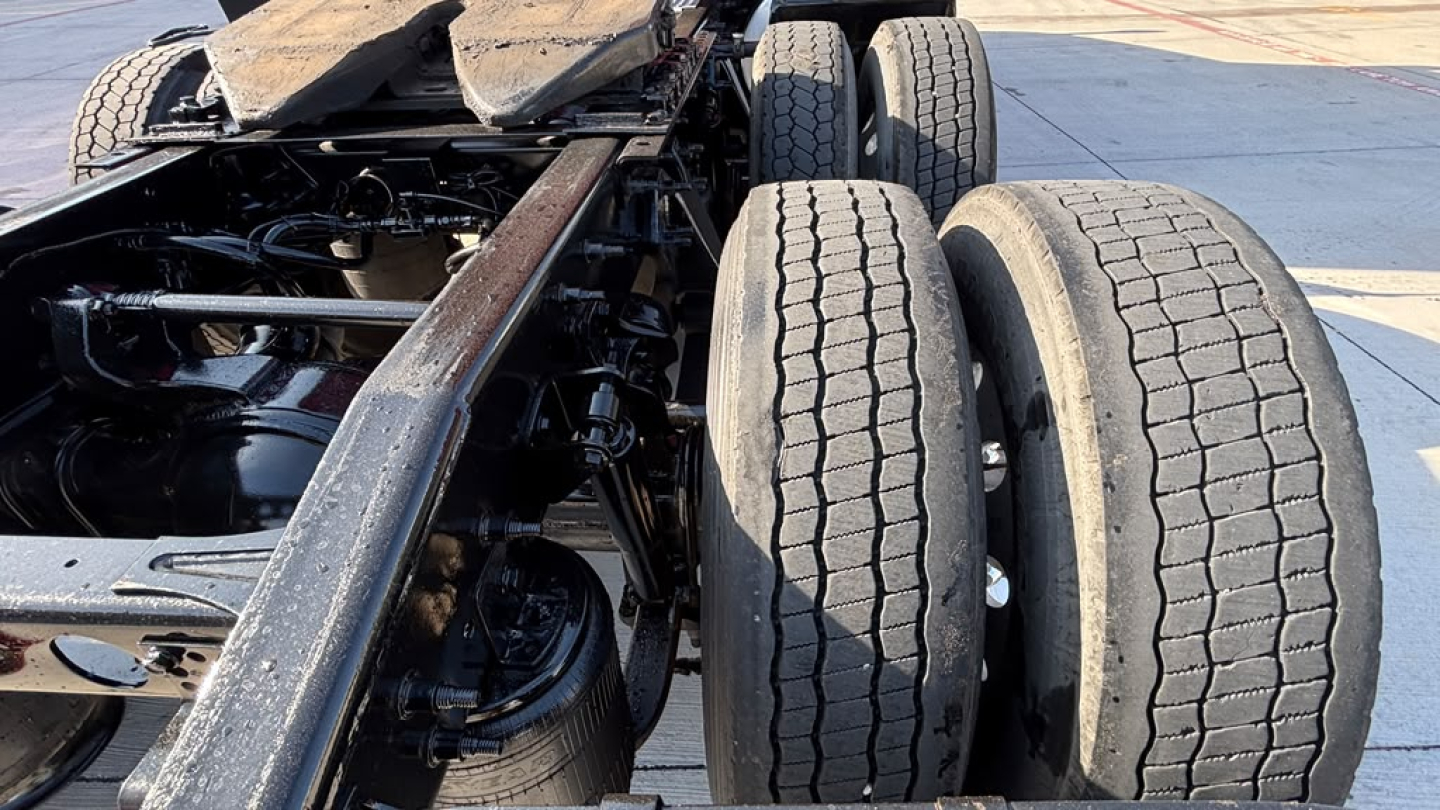 Truck chassis rear view showing dual rear axles, tires, and frame rails under a used 2022 International LT625 sleeper cab.