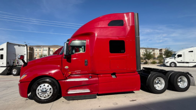 Truck side view of a red 2022 International LT625 sleeper tractor showing the cab and rear axles.
