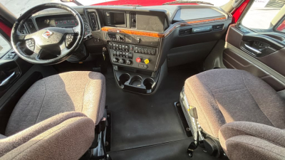 Cab interior of a 2022 International LT625 truck showing steering wheel, dashboard, center console, and two front seats.