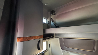 Cab interior of a 2022 International LT625 sleeper showing storage area and window