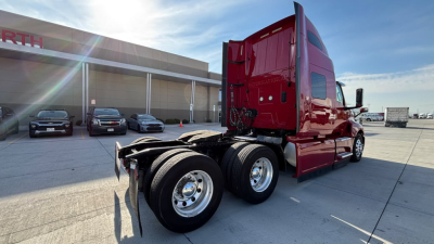 Truck image showing the rear and side view of a red 2022 International LT625 tractor with dual rear axles and chrome wheels.