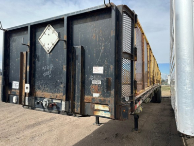 Manac closed tandem air ride steel flatbed trailer showing rear kit and reflective decals.