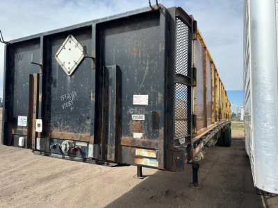 Flatbed trailer rear and side view showing steel hull, tandem air ride, various reflective plates and a small diamond-shaped placard on back.