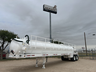 Trailer-mounted vacuum tanker (2026 Troxell 130BBL) showing cylindrical white tank on a dual-axle trailer with rear stair railing and undercarriage supports.