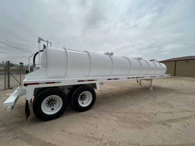 Vacuum trailer in view showing dual-axle white 130BBL tank with rounded cylindrical tank and tandem wheels.
