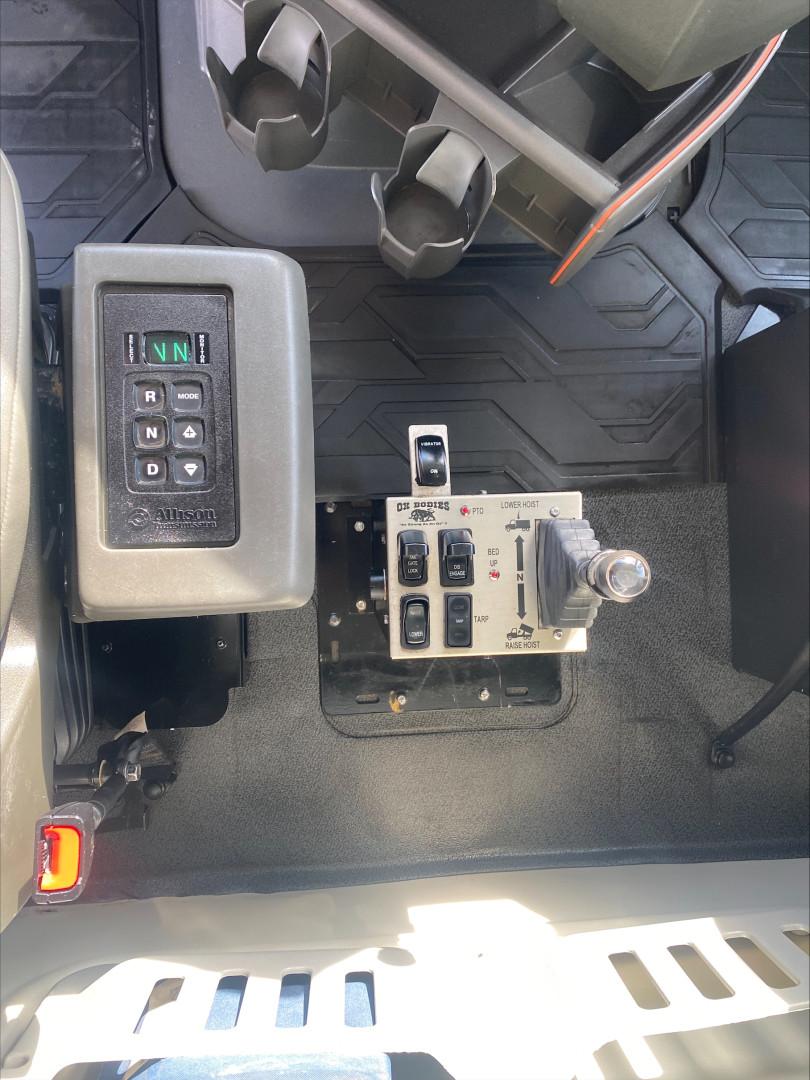 Volvo VHD dashboard area showing gear selector and control panel with levers and switches.
