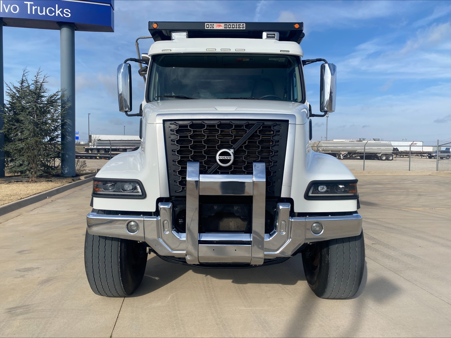Volvo VHD84F200 dump truck front view showing grille, bumper guard, and large side mirrors.