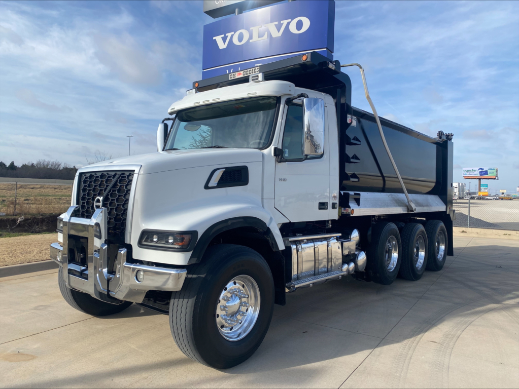 Volvo VHD84F200 dump truck side view showing chrome bumper, silver cab, and dump bed with Volvo sign on top.