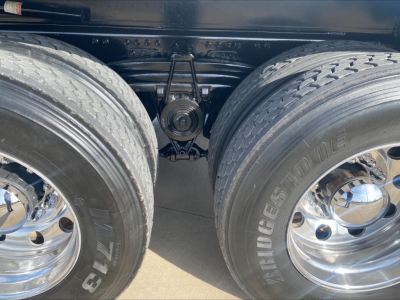 Dual rear wheels of a Volvo VHD truck showing suspension and driveshaft area between tires.