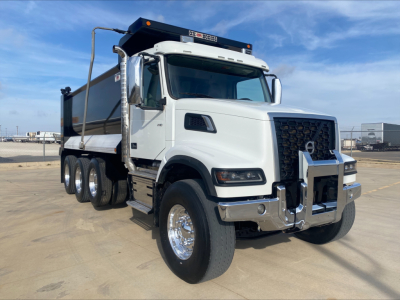 Volvo VHD84F200 dump truck with white cab and chrome bumper, side mirrors, and black dump bed. Front badge and grille visible; no legible small text.