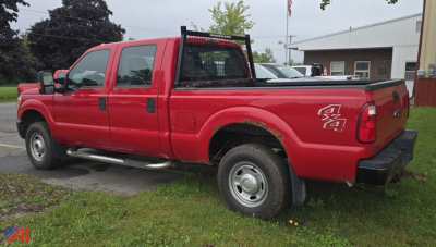Ford F-250 Super Duty crew cab long wheelbase single rear wheel side view showing red truck with black ladder rack and bed; visible trail-axle badge and wheel wells.