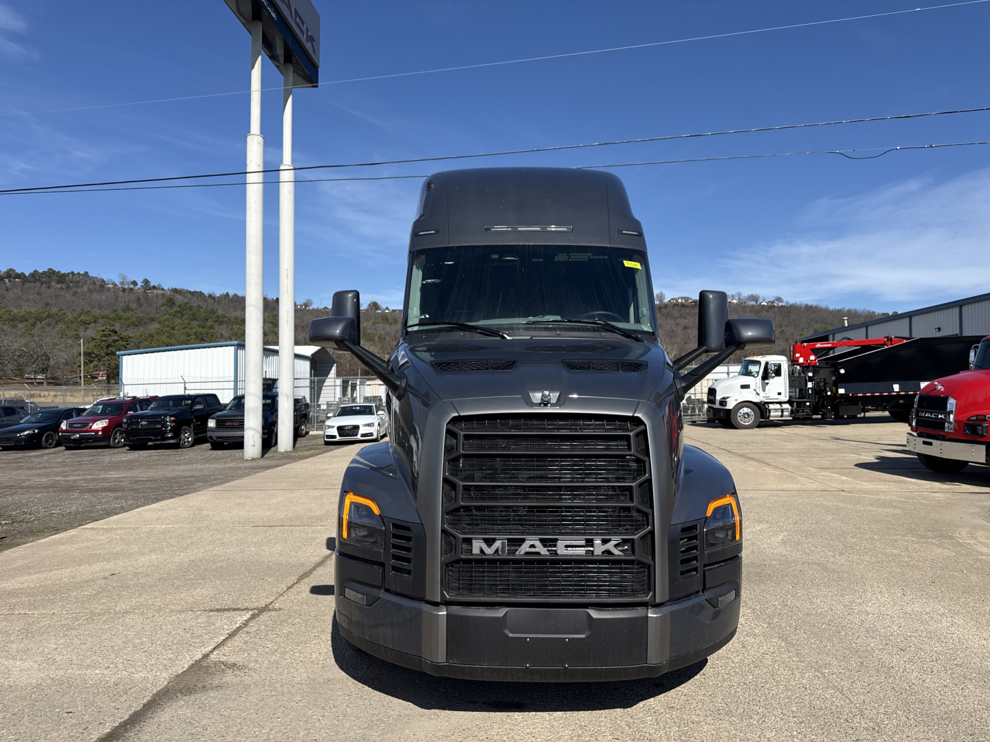 Conventional sleeper truck front view showing Mack PR64T76H with large grille, headlights, and bold MACK lettering.