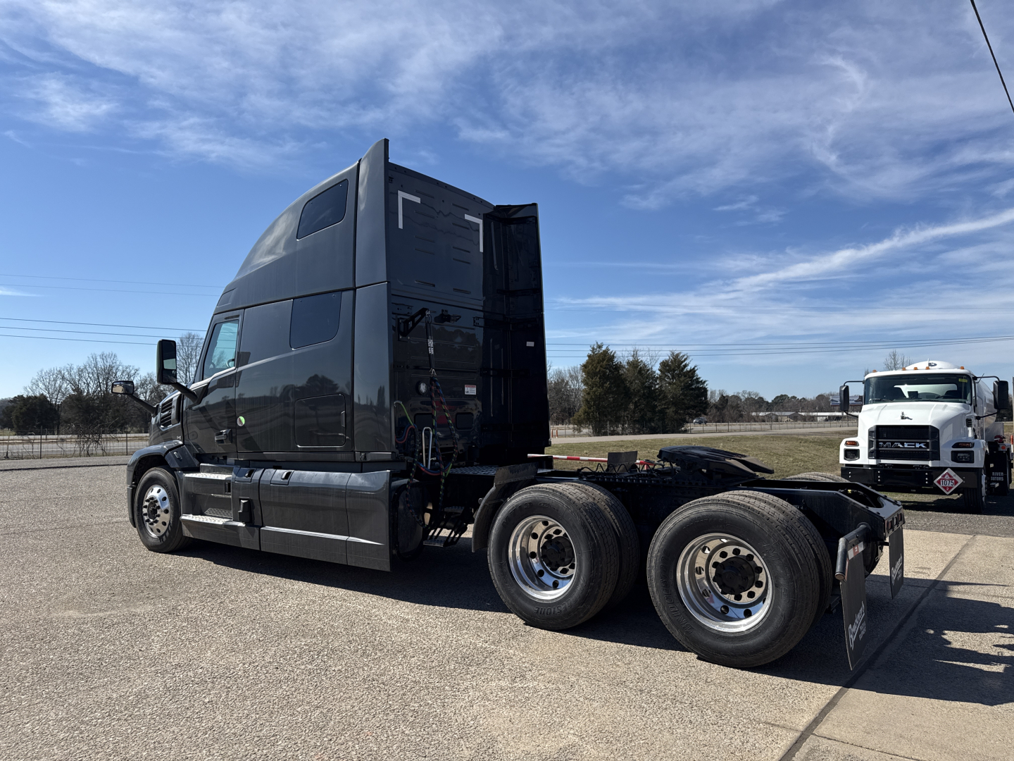 Mack PR64T76H conventional sleeper tractor side view showing cab and dual rear axles with black paint and chrome wheels.
