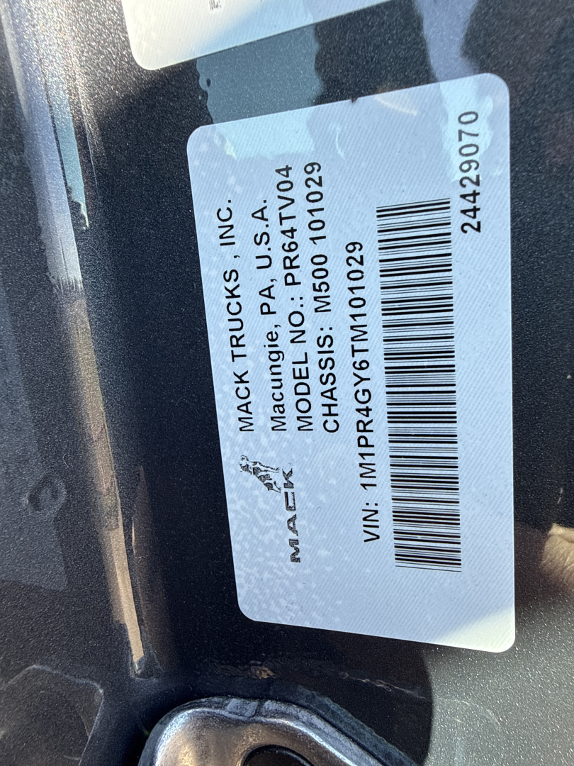 Mack truck label showing VIN 1M1PR4GY6TM101029 and model/serial details on a white sticker inside the door jamb.