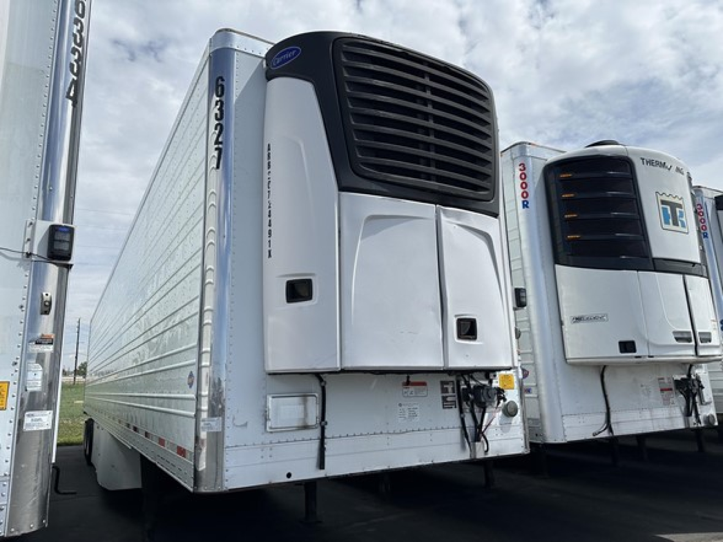 Trailer refrigeration unit on 2015 Utility 3000R reefer trailer, front view with cooling unit, side loading doors, adjacent unit, clear sky