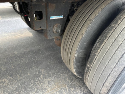 Trailer undercarriage showing tandem rear axles and wheel rims of a 2015 Utility 3000R reefer trailer with rusted frame and dirt on ground.