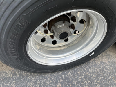Trailer wheel and tire with aluminum rim showing Michelin tire and hub area.